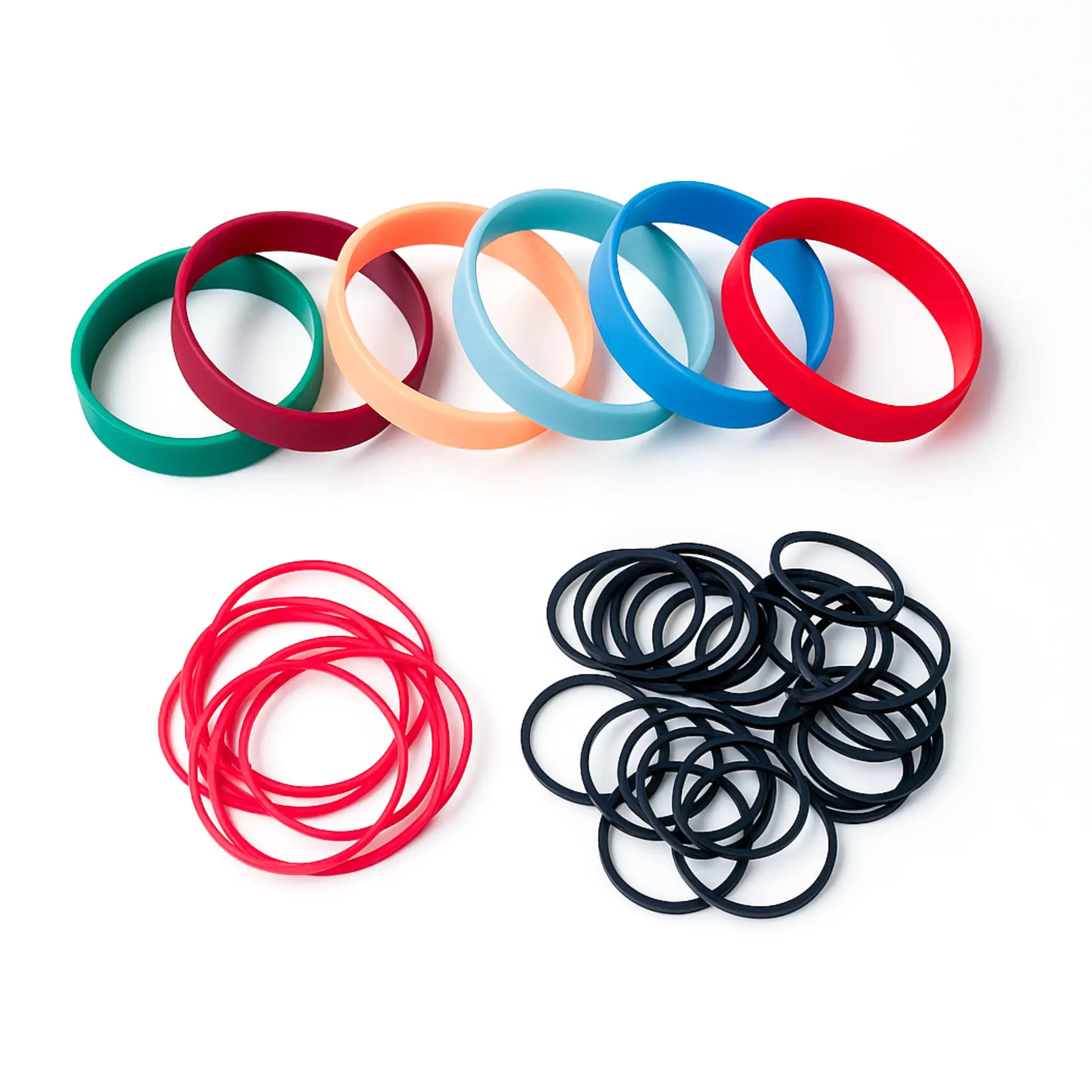 Assorted non-latex rubber bands in red, black, and multi-colored styles, offering KL Rubber’s B2B hypoallergenic packaging supply.