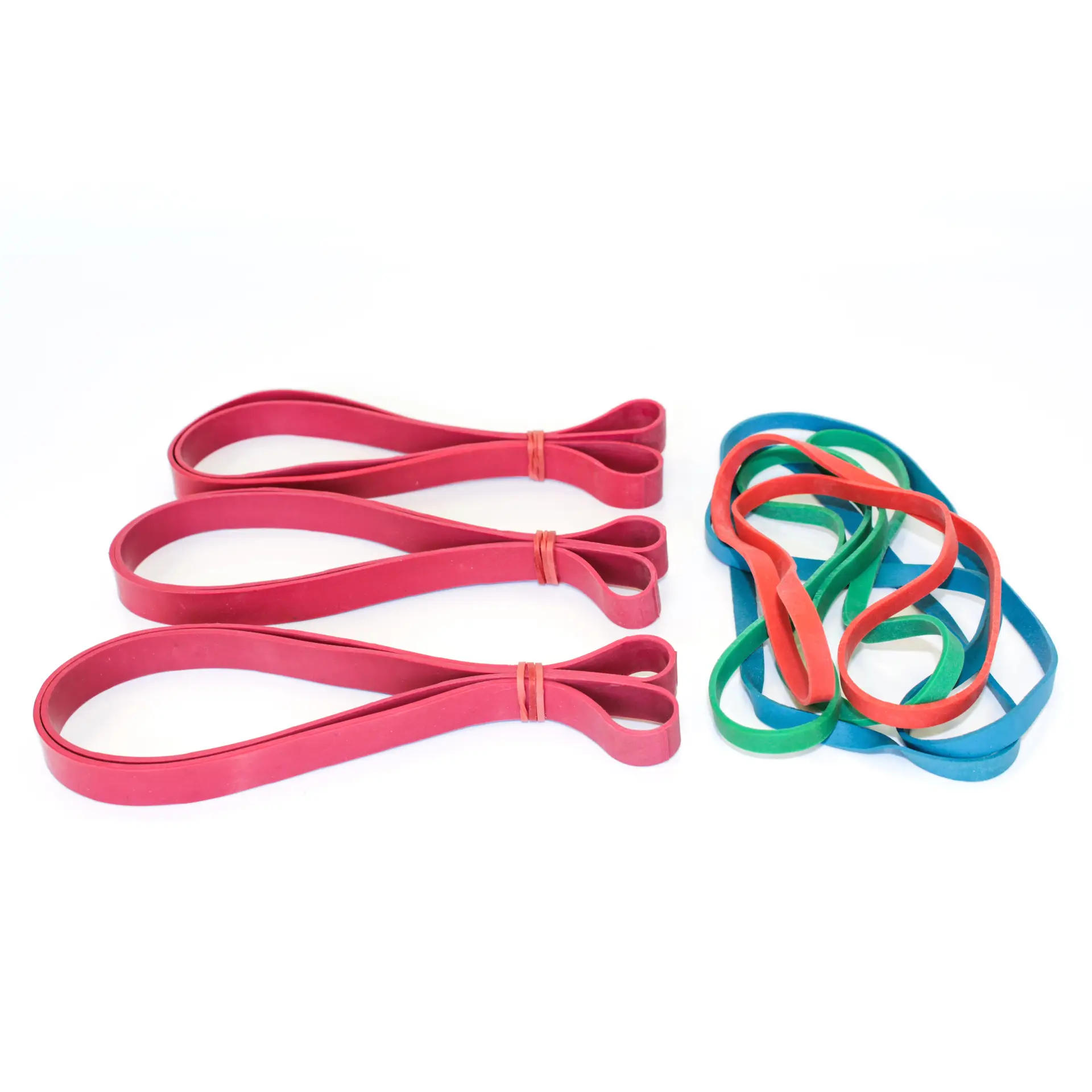 Large red, green, and blue oversize rubber bands, designed for bundling bulky items, highlighting KL Rubber’s B2B packaging supply.